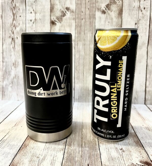 A black and white can of soda next to a lemon.