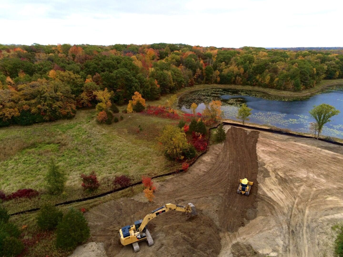 A large pond is being built with a tractor.