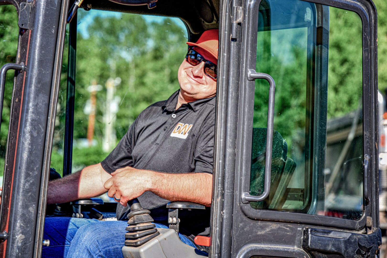 A man sitting in the cab of a tractor.