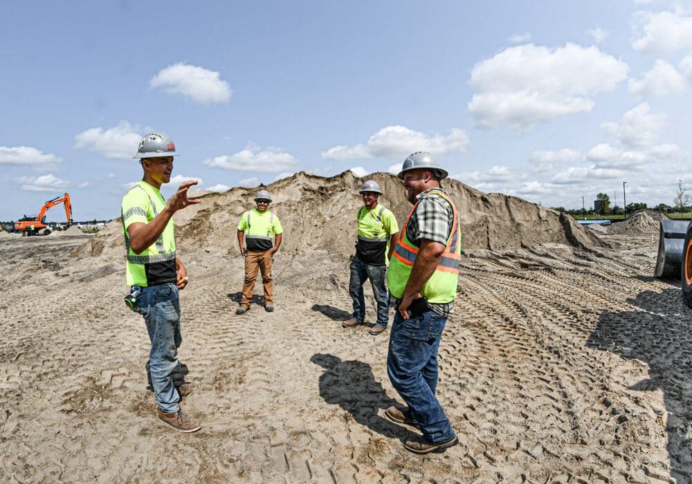 A group of men in yellow shirts and hard hats.